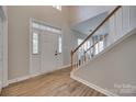 Bright foyer with wood-look tile flooring, staircase with wooden handrail and lots of natural light at 12719 Vantage Point Ln, Huntersville, NC 28078
