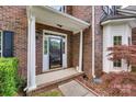 Close up of the front door area highlighting brick accents, white pillars and well-kept landscaping at 12719 Vantage Point Ln, Huntersville, NC 28078