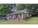 A view of the charming home, highlighting the inviting porch and classic architectural style, set on a green lawn at 1313 Maiden E Rd, Maiden, NC 28650