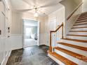 Inviting foyer with slate flooring, wainscoting, and a wooden staircase leading to the upper level at 1581 Granville Rd, Rock Hill, SC 29732