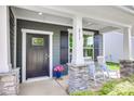 Inviting front porch with stone pillars, rocking chairs, and a stylish front door at 217 Barberry Dr, Belmont, NC 28012