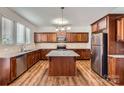Well-lit kitchen features wood cabinets, stainless steel appliances, and granite countertops at 2327 Glenway Trail Ct, Pineville, NC 28134