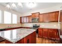 Kitchen features a large island, stainless steel appliances, warm wood cabinets and tile backsplash at 2327 Glenway Trail Ct, Pineville, NC 28134