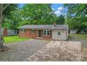 Beautiful one-story home featuring a brick facade, chimney, and a leaf-covered driveway at 2401 Woodleaf Dr, Gastonia, NC 28052