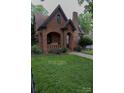 Beautiful brick home featuring an arched porch, black trim, and a well-manicured lawn at 324 N 5Th St, Albemarle, NC 28001