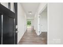 Bright hallway with wood-look floors and white walls, leading to various rooms in the home at 4016 Cramer Estates Ct, Gastonia, NC 28056