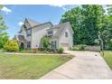 Spacious two-story home with an attached garage, well-maintained lawn, and colorful flower beds at 4225 Abernathy Pl, Harrisburg, NC 28075
