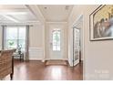 Inviting foyer with hardwood floors, decorative moldings, and a glass-paneled front door at 4225 Abernathy Pl, Harrisburg, NC 28075