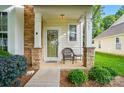 Inviting front porch showcasing stone pillars, decorative wreath on the door, and a cozy seating arrangement at 541 River Park Rd, Belmont, NC 28012