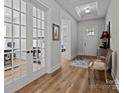 Elegant foyer with hardwood floors, tray ceiling, and French doors, creating a grand entrance to the home at 7010 Brush Crk, Monroe, NC 28110