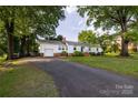 Well-maintained single Gathering home with attached garage and a paved driveway surrounded by green lawn at 80 Pine St, Badin, NC 28009