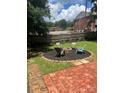 Backyard fire pit area featuring brick patio and multiple chairs perfect for outdoor entertaining at 80 Pine St, Badin, NC 28097