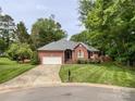 Well-maintained brick home with a two-car garage and a lush, green lawn at 8105 Rachel Ct, Waxhaw, NC 28173