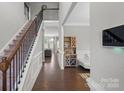 Inviting foyer with hardwood floors, staircase with iron railing, and a view into the living spaces at 8347 Dallas Bay Rd, Charlotte, NC 28278