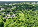 High-angle shot revealing a leafy suburban area with residential streets and verdant trees at 84 Sumner Nw Ave, Concord, NC 28027