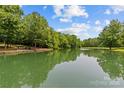 Scenic pond reflecting the blue sky and surrounding trees, creating a tranquil and inviting community space at 9831 Sedgefield Dr, Waxhaw, NC 28173