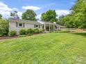 Well-maintained lawn with a view of a charming brick home and surrounding greenery at 1031 Eldorado Ave, Charlotte, NC 28262