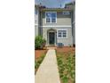 Exterior of a townhome featuring manicured lawn and walkway to the front door at 105 Woodsong Ln, Mooresville, NC 28117