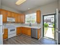 Bright kitchen featuring updated appliances, laminate flooring, and a view of the outdoors at 105 Woodsong Ln, Mooresville, NC 28117