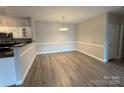 Open-concept dining area with wood floors and modern lighting at 10673 Hill Point Ct, Charlotte, NC 28262
