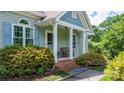 Charming front porch with seating and colorful landscaping, creating an inviting and picturesque curb appeal at 109 Gatwick Ct, Statesville, NC 28677