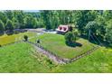 Aerial view of rustic home with pond, fencing, and wooded area on beautiful property at 11227 Cool Springs Rd, Cleveland, NC 27013