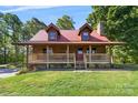 Charming log cabin home featuring a metal roof, covered front porch, and manicured lawn at 11227 Cool Springs Rd, Cleveland, NC 27013