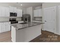 Modern kitchen featuring an island with granite countertops, stainless steel appliances, and white cabinets at 1512 Doran Ter, Richburg, SC 29729