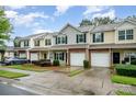 Well-manicured townhomes featuring garages, landscaping, and sidewalks create a welcoming neighborhood setting at 15554 Stronvar House Ln, Charlotte, NC 28277
