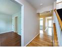 A bright hallway with hardwood floors connecting multiple rooms and a staircase at 15623 Sir Charles Pl, Charlotte, NC 28277