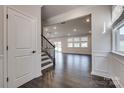 Light and airy hallway with hardwood floors, staircase, and view of the open living area at 16042 River Tree Ln, Charlotte, NC 28278