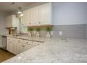 Bright kitchen featuring sleek countertops, modern backsplash, and white cabinetry at 1610 Ford St, Charlotte, NC 28216