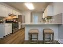 Kitchen features stainless steel appliances, a breakfast bar with seating, and hardwood floors at 1610 Ford St, Charlotte, NC 28216