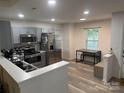 Updated kitchen features stainless steel appliances, gray cabinets, and a dining area with natural light at 1623 Flagler Ln, Charlotte, NC 28216