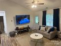Comfortable living room features a modern ceiling fan, stylish furniture, and a large television on the wall at 1623 Flagler Ln, Charlotte, NC 28216