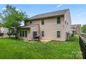 A large backyard featuring a well-kept lawn, black fence, and a grill on a patio at 16615 Crimson Sargent Dr, Charlotte, NC 28213