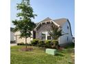 Single-Gathering home with light gray siding, stonework accents, a lush lawn, and mature landscaping at 1825 Lotus Ln, Denver, NC 28037