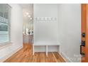 Bright entryway with hardwood floors, built-in bench, and view into the modern kitchen at 1830 Wickford Pl, Charlotte, NC 28203