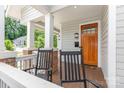 Inviting covered porch with rocking chairs, wood flooring, and a stylish front door at 1830 Wickford Pl, Charlotte, NC 28203