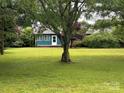 Inviting front yard with well-maintained lawn and mature trees, creating a picturesque and tranquil environment at 2009 Hickory Grove Rd, Gastonia, NC 28056