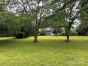 Spacious front yard showcasing mature trees and lush green grass, providing a park-like setting for the home at 2009 Hickory Grove Rd, Gastonia, NC 28056