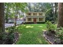 Charming two-story home with a manicured lawn, lush landscaping, and a detached garage with ample parking at 201 Scalybark Trl, Concord, NC 28027
