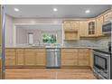 Well-lit kitchen features stainless steel appliances, granite countertops, and honey colored cabinetry with a wood floor at 201 Scalybark Trl, Concord, NC 28027