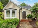 Close up of quaint home with bay window, arched door, and manicured landscaping at 2432 Hassell Pl, Charlotte, NC 28209