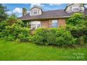Charming brick home featuring dormer windows and lush greenery, creating a welcoming facade at 2505 Charlotte Hwy, Fort Mill, SC 29707