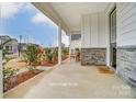 Inviting front porch with stone accents, cozy seating, and manicured landscaping at 2517 Mabel Ln, Monroe, NC 28110