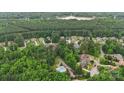 An aerial shot showcasing the neighborhood's lush greenery, mature trees, and a glimpse of the lake in the distance at 309 Palm Cove Way, York, SC 29745