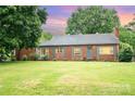 Charming brick home featuring a well-manicured front lawn and classic architectural details, great curb appeal at 3700 Nevin Rd, Charlotte, NC 28269