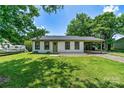 Well-maintained white brick home with a lovely green lawn and a convenient carport at 413 Picadilly Ln, Troutman, NC 28166