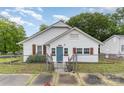 Charming exterior of home with white siding, blue front door, and fenced yard at 417 S Broad St, Gastonia, NC 28052